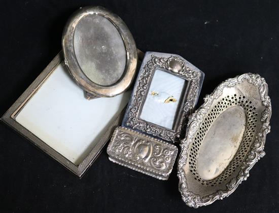 A rectangular embossed silver box, Chester 1895, Nathan & Hayes, an oval pierced silver dish and three silver-mounted photograph frames